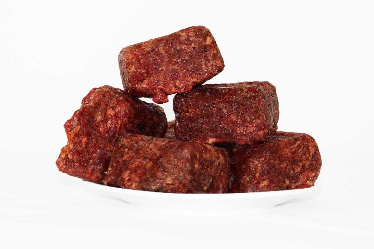 1kg beef mince meat cubes stacked on white plate for high energy dogs