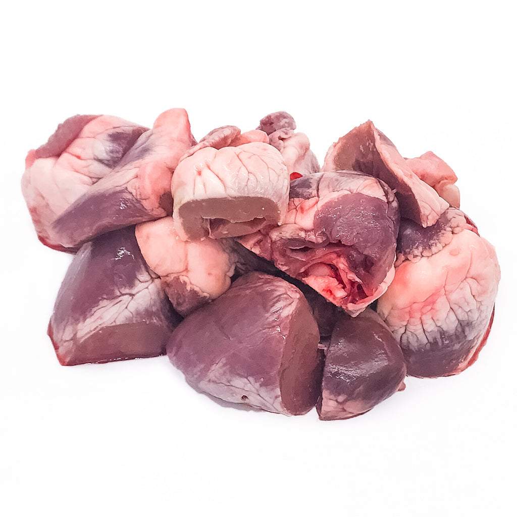 Pile of raw lamb heart pieces isolated on white background