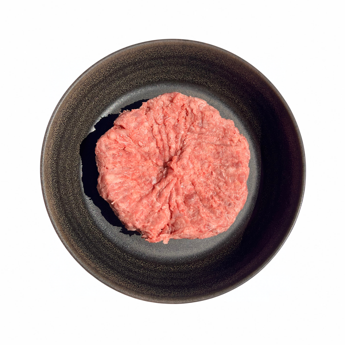 Chicken & Beef Mince, pink ground meat with a coarse, uneven texture, shaped into a round mound on a dark plate.
